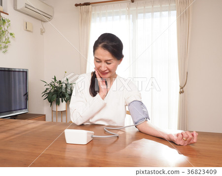 Middle woman who measures blood pressure 36823409