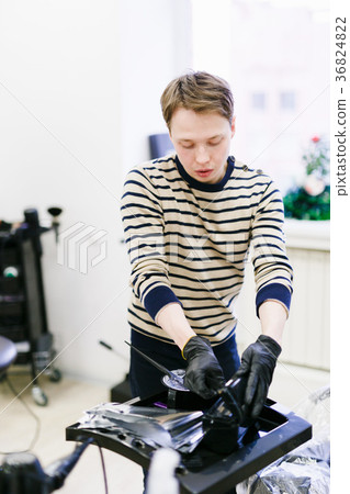 the hairdresser in the salon makes hair coloring 36824822