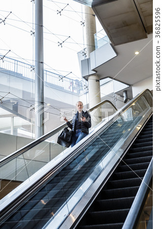 Businesswoman with large black bag and mobile Businesswoman with large black bag and mobile 36825596