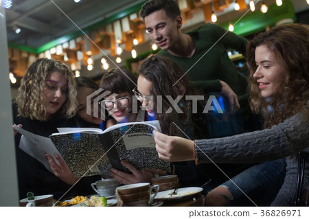Group of teenagers doing homework in cafe. Group of teenagers doing homework in cafe. 36826971