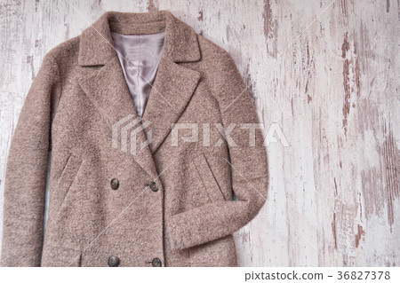 Brown woolen coat, wooden background 36827378