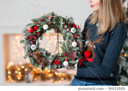 Young woman holding a Christmas wreath with fir 36832689