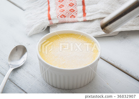 caramelising creme brulee with torch 36832907