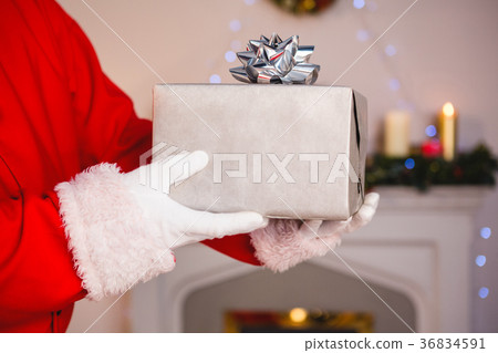 Santa claus holding a gift Santa claus holding a gift 36834591