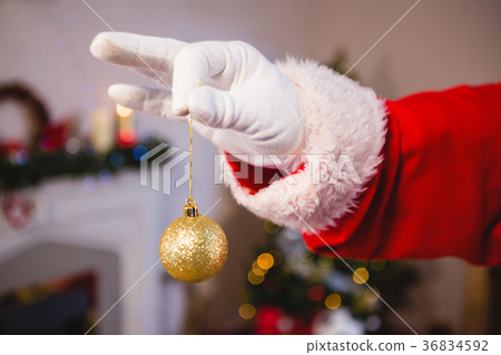 Santa claus holding a bauble Santa claus holding a bauble 36834592