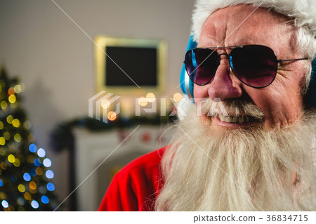Santa Claus listening to music on headphones 36834715