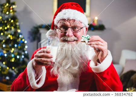 Santa Claus having christmas cookie with a glass of milk 36834762