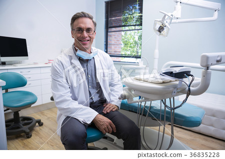 Portrait of smiling dentist sitting on chair 36835228