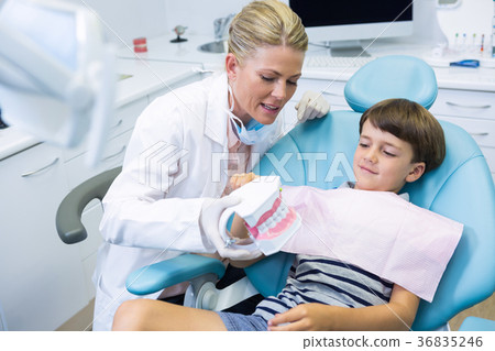 Dentist holding dental mould while talking with boy 36835246