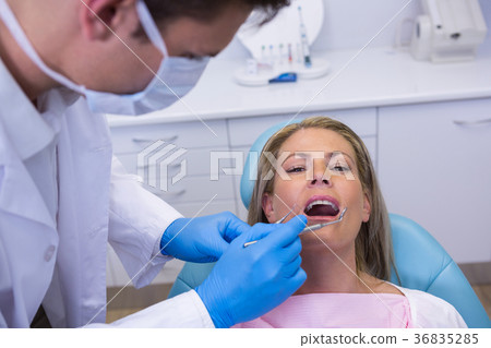 Doctor giving dental treatment to woman at clinic 36835285