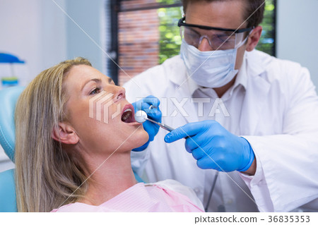 Close-up of doctor wearing surgical mask examining patient 36835353