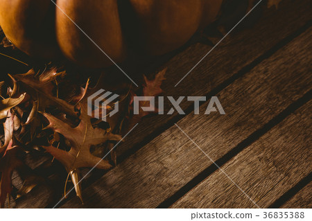 Cropped image of pumpkin with autumn leaves on table 36835388