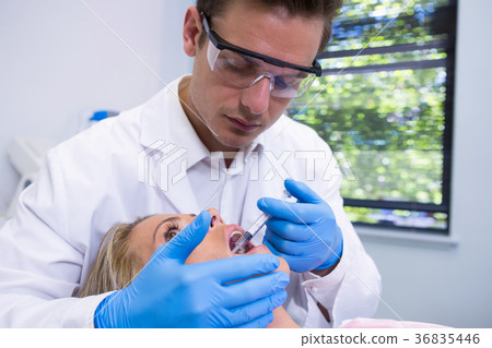 Dentist giving anesthetic to woman at medical clinic 36835446