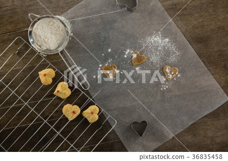 Sieve with icing sugar cookies on cooling rack 36835458