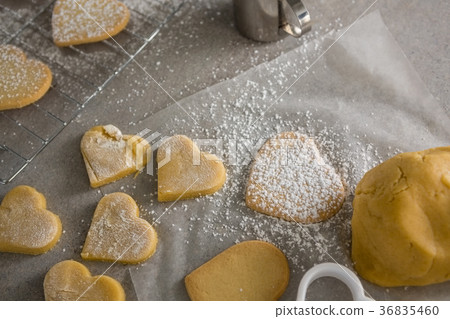 Raw heart shape cookies with sugar icing on wax paper Raw heart shape cookies with sugar icing on wax paper 36835460
