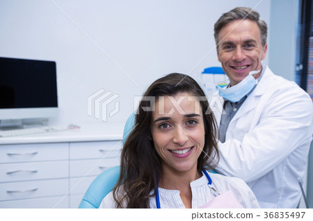 Portrait of patient sitting on chair by dentist Portrait of patient sitting on chair by dentist 36835497