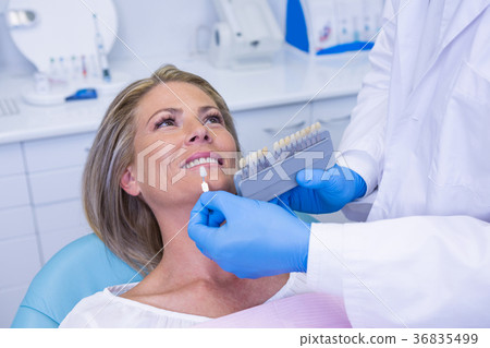 Doctor holding tooth whitening equipment by patient Doctor holding tooth whitening equipment by patient 36835499