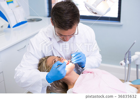 High angle view of dentist examining woman with dental equipments 36835632