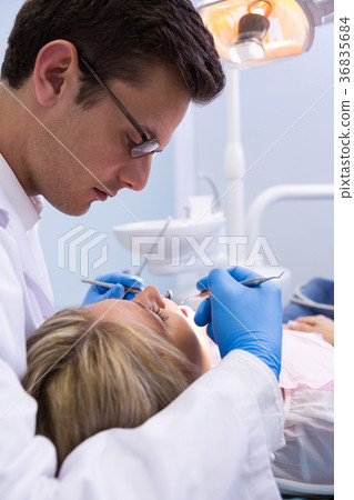 Close up dentist examining woman with dental equipments 36835684