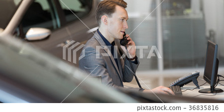 Salesman talking on landline phone in showroom Salesman talking on landline phone in showroom 36835816