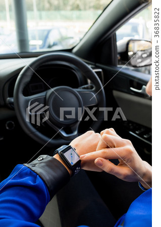 Cropped image of woman using smart watch in car 36835822