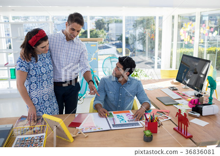 Team of graphic designers discussing over document 36836081