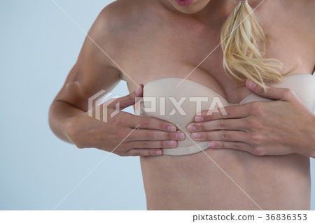 Mid section of woman checking breast for lumps Mid section of woman checking breast for lumps 36836353