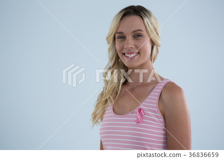 Portrait of smiling young female in tank top with pink ribbon 36836659