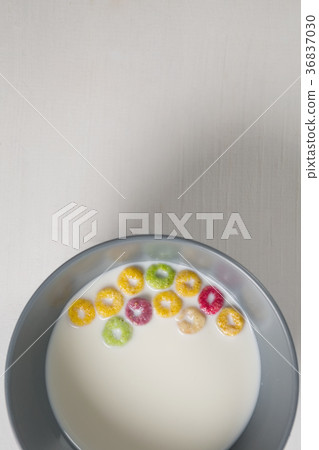 Bowl of milk and cereal rings on white background 36837030