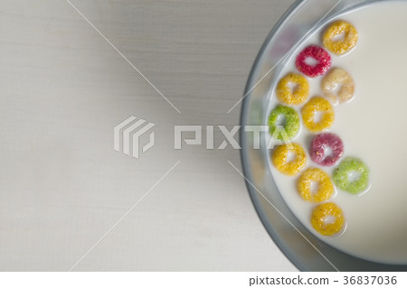 Bowl of milk and cereal rings on white background 36837036