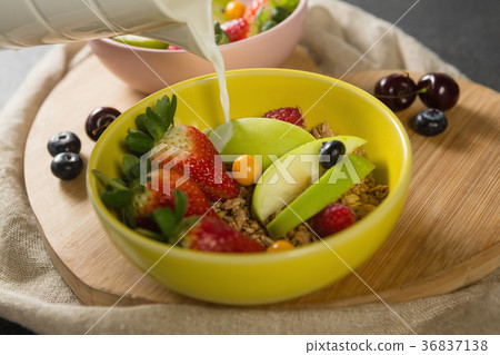 Milk being poured into bowl of breakfast cereal 36837138