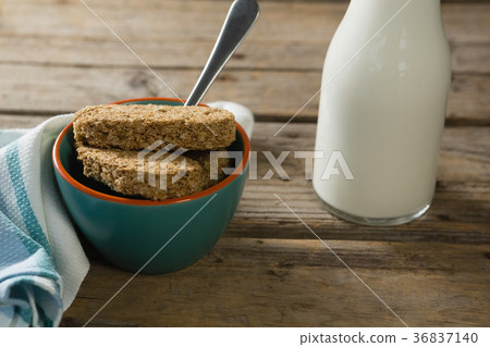 Granola bar and milk with napkin on wooden table 36837140
