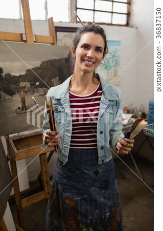 Woman holding various brushes in drawing class Woman holding various brushes in drawing class 36837150