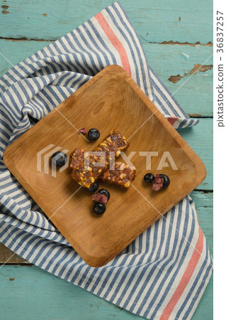 Granola bar and blueberry on wooden plate 36837257
