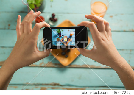Hands taking photo of breakfast with mobile phone Hands taking photo of breakfast with mobile phone 36837292