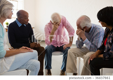 Senior friends looking at man with head in hand Senior friends looking at man with head in hand 36837661