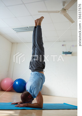 Yoga instructor doing forearm stand at health club Yoga instructor doing forearm stand at health club 36837876