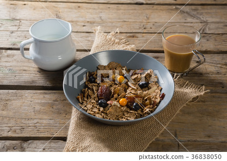 Bowl of wheat flakes, blueberry and golden berry with milk jug Bowl of wheat flakes, blueberry and golden berry with milk jug 36838050