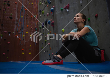 Thoughtful athlete looking up while relaxing in club 36838089