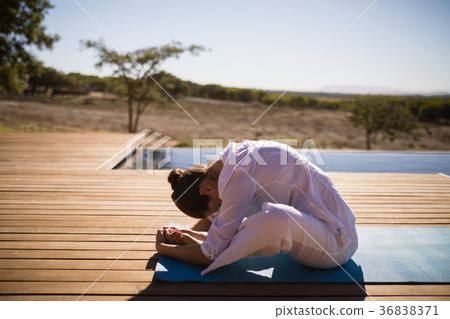 Woman practicing yoga on at poolside Woman practicing yoga on at poolside 36838371