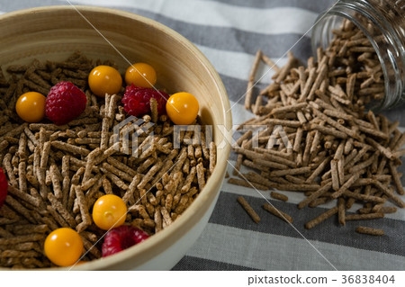 Bowl of cereal bran stick with golden berries and raspberries Bowl of cereal bran stick with golden berries and raspberries 36838404