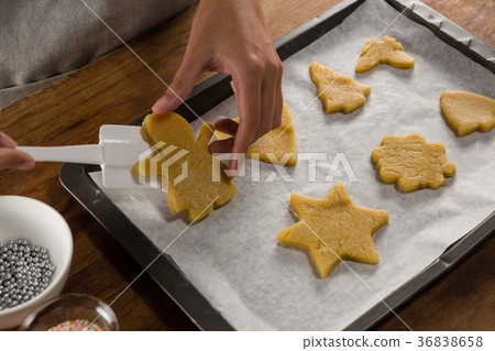 Man placing gingerbread cookies in baking tray Man placing gingerbread cookies in baking tray 36838658