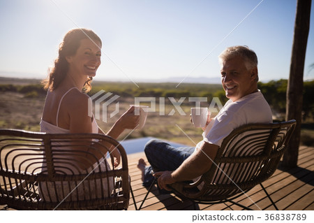 Senior couple having coffee while sitting at the resort Senior couple having coffee while sitting at the resort 36838789