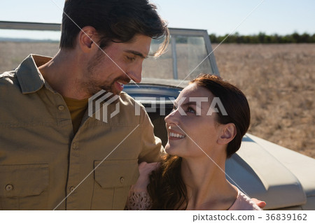 Couple by off road vehicle looking at each other 36839162
