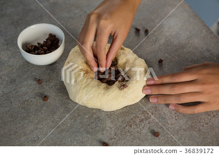 Woman adding chocolate chips into the dough Woman adding chocolate chips into the dough 36839172