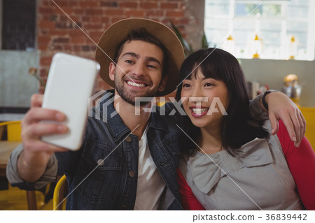 Man with woman taking selfie at cafe Man with woman taking selfie at cafe 36839442