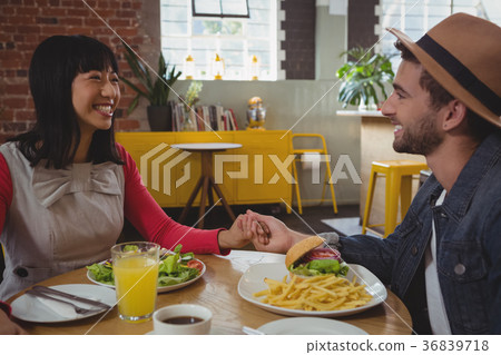 Couple holding hands at cafe 36839718