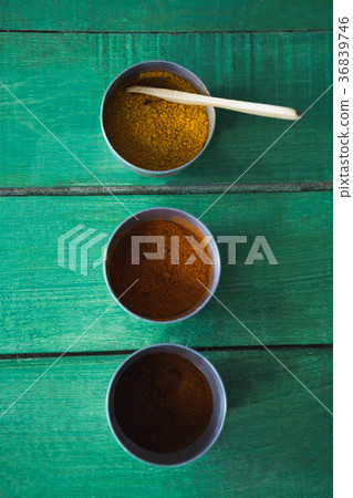 Cinnamon powder, chili powder and curry powder on wooden table 36839746