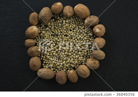White peppers surrounded with nutmegs 36840356