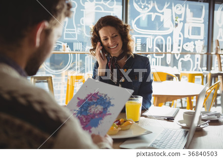 Man holding paper with painting by woman in cafe Man holding paper with painting by woman in cafe 36840503